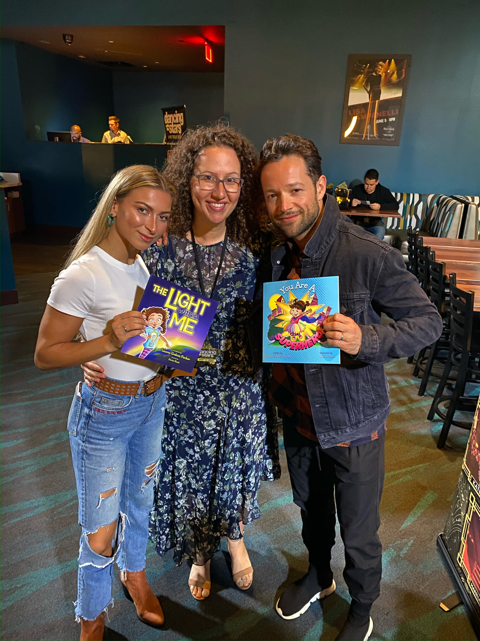 Lauren Grabois Fischer with Dancing With The Stars, Daniella Karagach and Pasha Pashkov holding 'The Light Within Me' and 'You Are A Superhero'