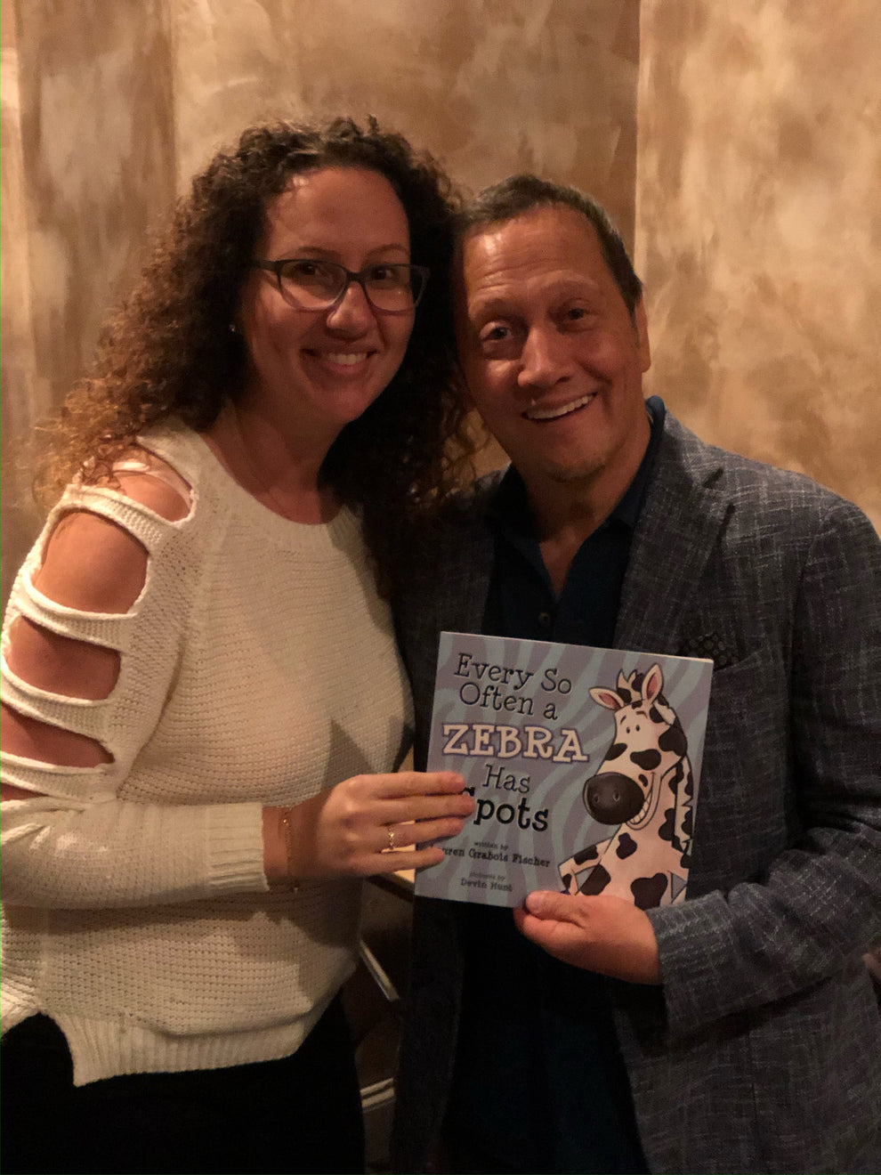 Lauren Grabois Fischer with Rob Schneider celebrating her children's book 'Every So Often a Zebra Has Spots' at a special event.