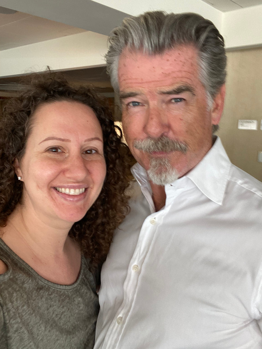 Lauren Grabois Fischer smiles alongside actor Pierce Brosnan, highlighting connections that inspire her impactful children's books on kindness